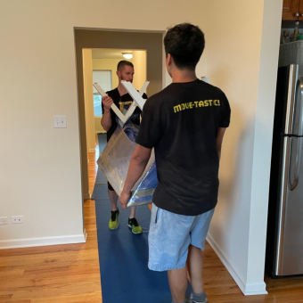 Movers carrying furniture through clean home