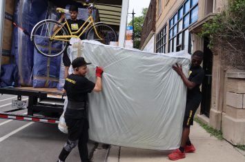 Two movers carrying a mattress