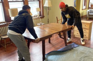 Two Movers wrapping a table