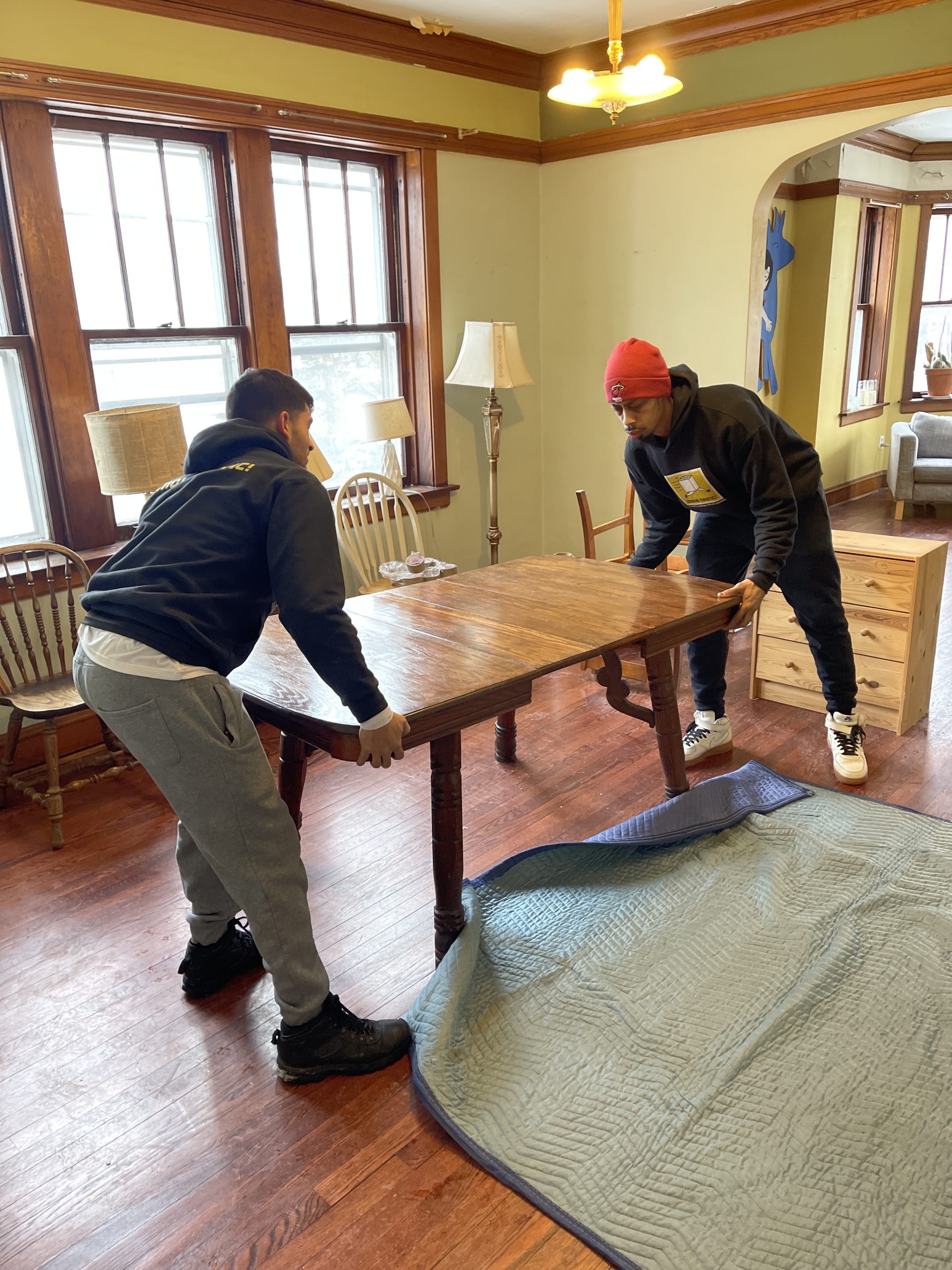 Two Movers wrapping a table
