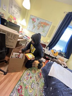 Mover demonstrating packing tips for moving: packing books in small boxes.
