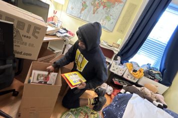 Mover demonstrating packing tips for moving: packing books in small boxes.